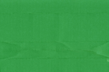 Fototapeta na wymiar A green vintage rough sheet of carton. Recycled environmentally friendly cardboard paper texture. Simple and bright minimalist papercraft background.
