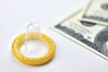 Condom on dollars bills