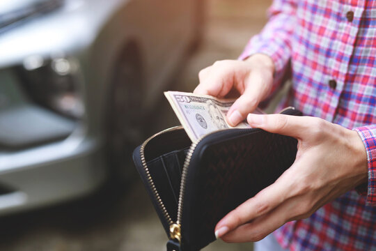 Business Woman Person holding a wallet in the hands of take money out of pocket stand front car prepare pay by installments - insurance, loan and buying car finance concept insurance, payment a car.