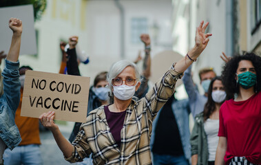 People with placards and posters on public demonstration, no covid vaccine and coronavirus concept.