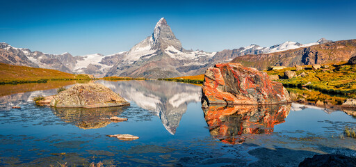 Astonishing summer scene of Stellisee lake. Panoramic morning view of Matterhorn (Monte Cervino,...