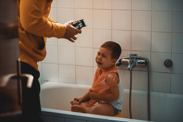 Father cutting son's hair at home during the 2020 pandemic lockdown. Covid-19 social distancing