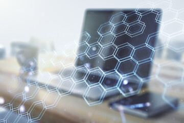 Creative concept of wireless technology with hexagon hologram and modern desktop with computer on background. Big data and database concept. Multiexposure