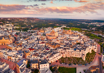 Fototapeta na wymiar Picturesque spring view from flying drone of Ostuni town, Italy, Europe. Stunning sunrise on Apulia. Traveling concept background. Splendid morning cityscape of Ostuni.