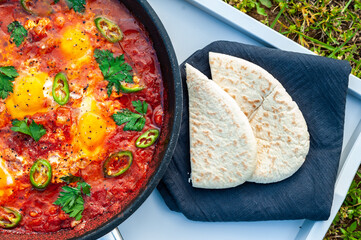 A view of Turkish menemen from top. This delicious dish is in a pan and on a tray.
