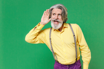 Curious shocked elderly gray-haired mustache bearded man in casual yellow shirt suspenders try to...