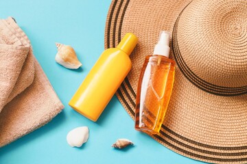Summer beauty flat lay photography. Sunscreen lotion, sunblock spray, towel and sun hat