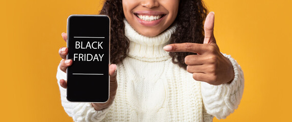 Woman showing cell phone with black friday text on screen