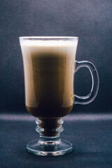 Creamy Irish coffee in a glass on black background. Shallow depth of field, blur, whiskey, drink, bokeh, Christmas.