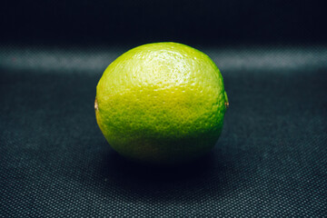 Single green lime on black background. Shallow depth of focus, blur, fruit, one, 1.