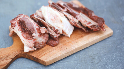 Close up photo of beef ribs on a cutting board with gray banckground