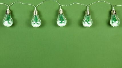 Fototapeta na wymiar Christmas garland of light bulbs and trees. Copy space