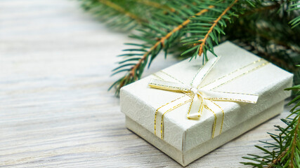 Fototapeta na wymiar Gift in a box and sprig of spruce. Christmas background, copy space