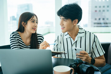 Two influencers doing live video streaming with computer laptop together.