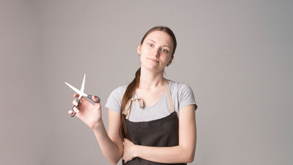 Young beautiful female hairdresser holding  hair clipper