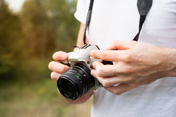 junger mann fotografiert mit vintage kamera detail fotografieren hobby natur fotografie lifestyle