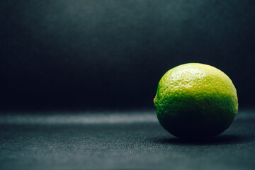 Single green lime on black background. Shallow depth of focus, blur, fruit, one, 1.