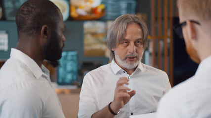 Male restaurant manager giving team talk to waiting staff