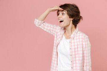 Excited surprised cheerful young brunette woman 20s in casual checkered shirt standing holding hand...