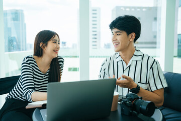 Two influencers doing live video streaming with computer laptop together.