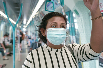 Fototapeta na wymiar Woman commuter wearing face mask inside train