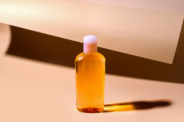 Orange cosmetic shampoo, gel on beige rolled paper background