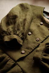 Fragment of an olive colored linen dress. puff sleeve