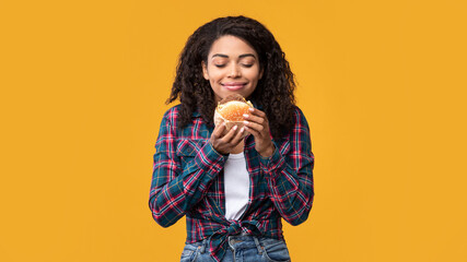 Closeup Of African American Lady Eating Tasty Burger At Studio