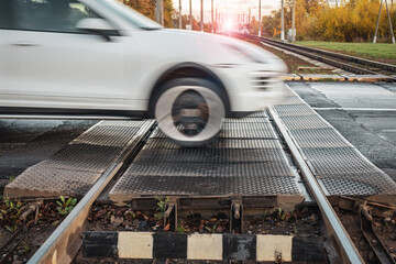 Blurred car railroad crossing, car runs over rails, level crossing, road hazard,
