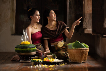 Two thai woman in traditional dress costume making and decorating Krathong. Loy Krathong Festival.