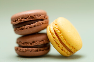Colored tasty macaroons over a green background.