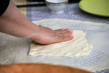 Closeup of hands of algerian woman making msemens at the market