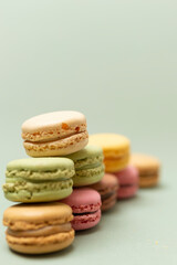 Colored tasty macaroons over a green background.