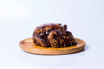 Roast chicken on a wooden tray on white background
