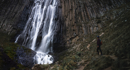 a man looks at a waterfall