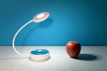 red apple and electric lamp on the table