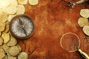 Fototapeta na wymiar Old compass and gold coins treasure over antique map. top view