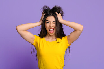 Fototapeta premium Mad Mood. Crazy Asian Woman Touching Tousled Hair And Winking At Camera