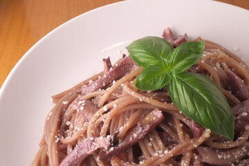 テーブルの上の赤ワインソースのきのこのスパゲッティ・バジル・パルメザンチーズ