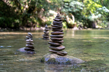 Relaxed view of a pyramid of stones balanced on a river water