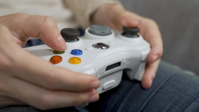 The Gamer Person Plays a Computer Games Using a Gamepad. Close-up of the Controller, and the Hand Presses the Button on.