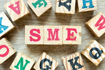 Alphabet letter block in word SME (abbreviation of Small and medium sized enterprises) with another...