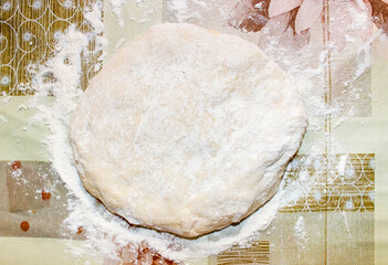 Yeast dough sprinkled with flour on the table.