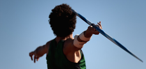 Athlete about to throw a javelin in the stadium	