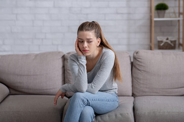 Mental health concept. Young woman having depression on sofa at home
