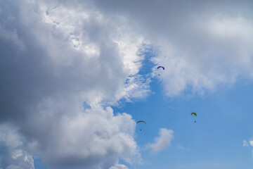 Paragliding in the cloudy blue sky.