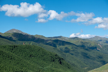 Panoramic view on a mountain range covered by green forest and view on ruins of upper Chazhash...