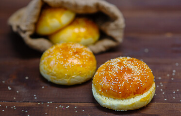 Burger buns lie on dark wooden background