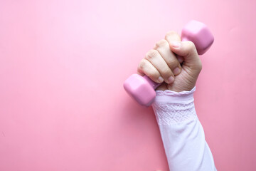  top view of woman hand holding pink dumbbell.