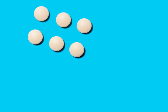 image of white tablets on a blue background.